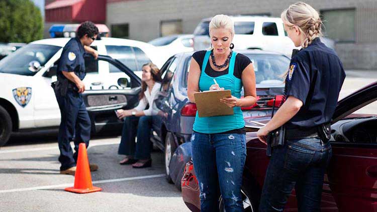 Una mujer llenando un informe de accidente en el estacionamiento.