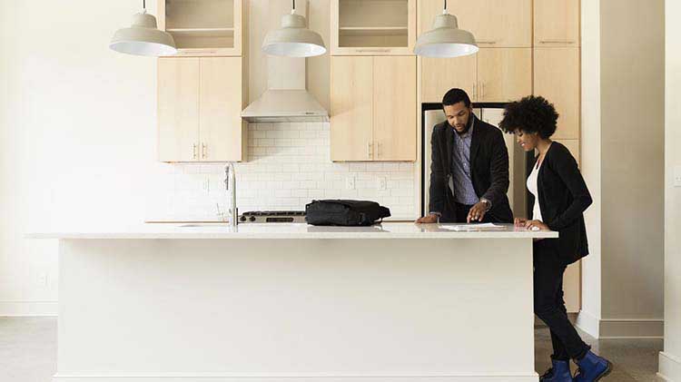 Un corredor de bienes raíces revisa con una compradora los costos asociados con la compra de una vivienda.