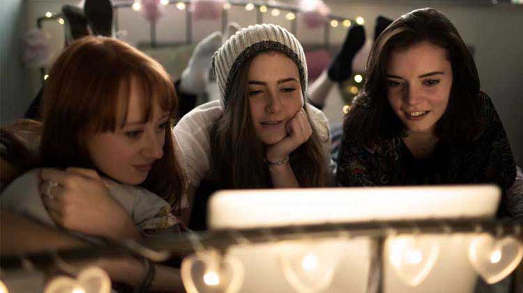 Adolescentes viendo fotos en redes sociales en una tableta