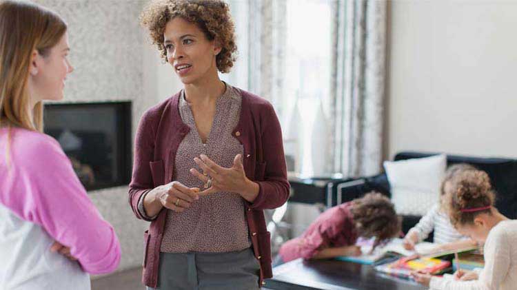 Una mamá da instrucciones a la niñera sobre el cuidado de los niños.