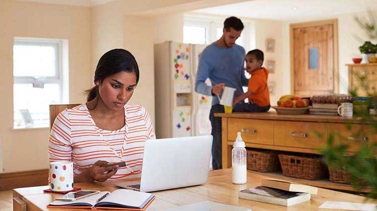 Una mujer trabajando en la computadora para analizar sus deudas.