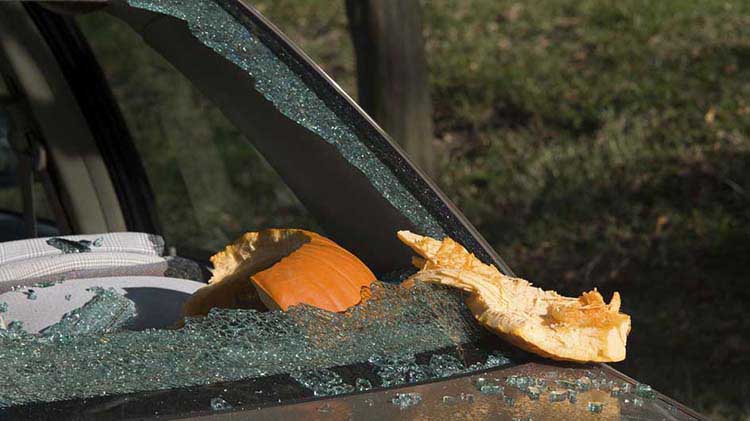 Parabrisas de carro destrozado por una calabaza