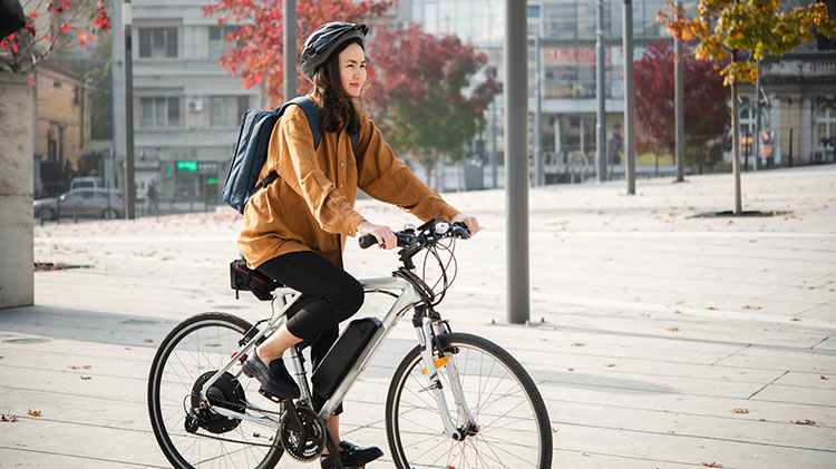 Una mujer en una bicicleta eléctrica camino a su trabajo.
