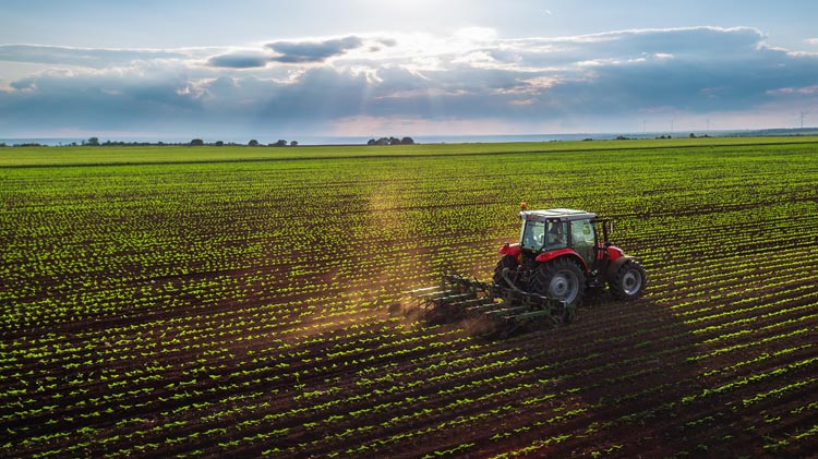 Vista aérea de un tractor cultivando el terreno en la primavera.