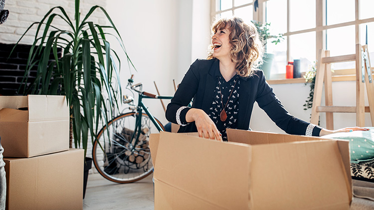 Una mujer está desempacando cajas después de mudarse a su nuevo lugar.