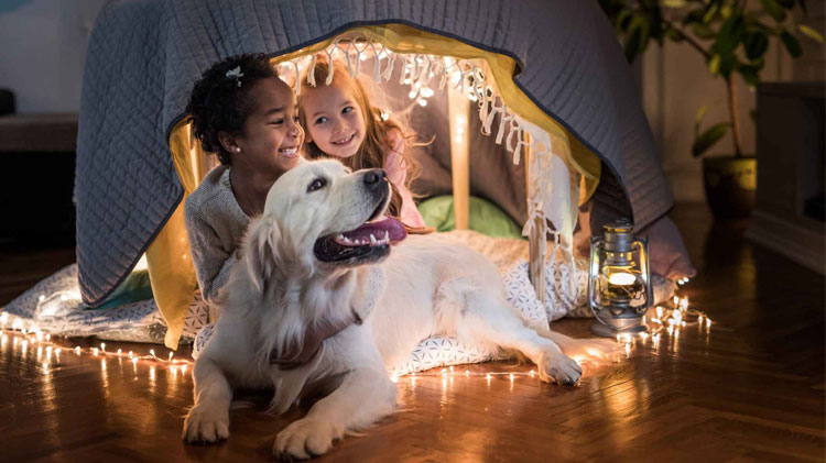 Niñas felices relajándose con golden retriever.