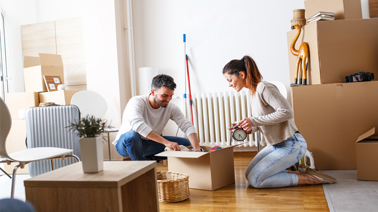Una pareja joven desempaca unas cajas en su nuevo apartamento.