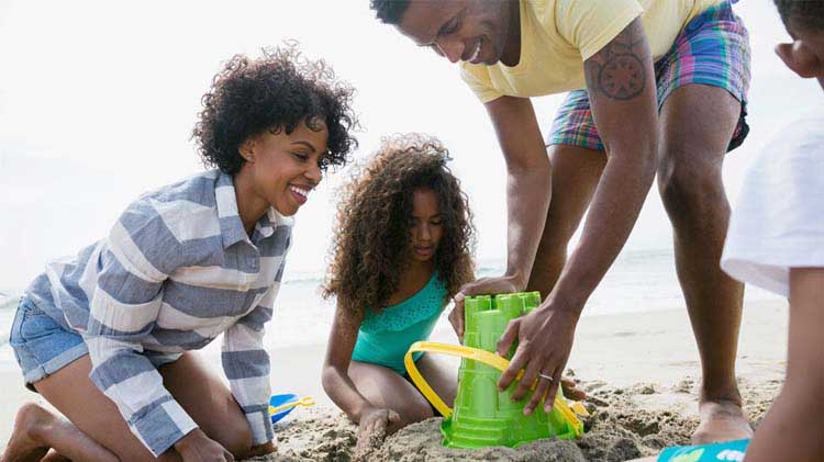 Familia jugando en la arena en la playa.