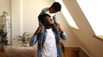 Hijo apoyado en los hombros de su padre.